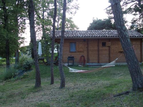 a hammock in front of a log cabin at Chalets du Bois de Vache in Le Poët-Célard