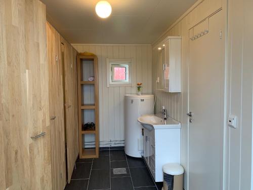 uma pequena casa de banho com um lavatório e um frigorífico em TINEBUA Basecamp Senja em Berg