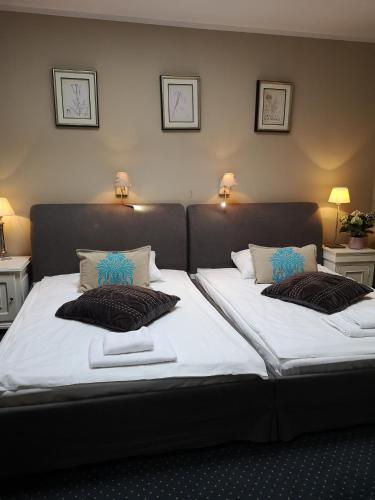 a bedroom with two beds with white sheets and pillows at Riviera Resort Airport Modlin in Olszewnica Nowa