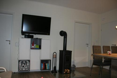 a living room with a flat screen tv on a wall at Holunder Hüsken in Oberlangen