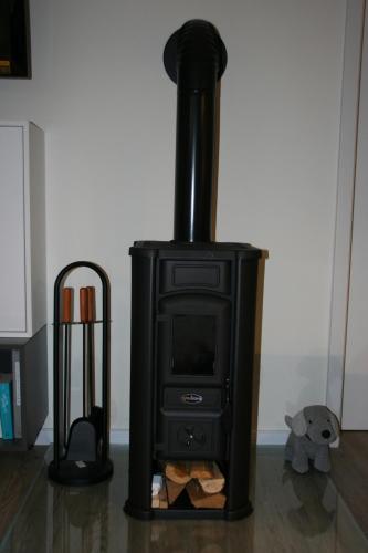 a black stove sitting in a living room at Holunder Hüsken in Oberlangen
