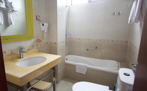 y baño con lavabo, bañera y aseo. en Hera Addis Hotel en Addis Abeba