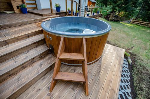 a jacuzzi tub on a deck with a ladder at Chata Pod Lasem in Poręba