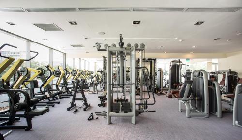 a gym with a lot of treadmills and machines at Kronwell Brasov Hotel in Braşov