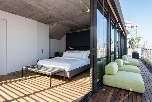 een slaapkamer met een bed en een balkon bij The Levee in Tel Aviv