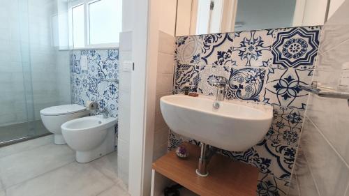 a bathroom with a sink and a toilet at Candiano Palace in Portopalo