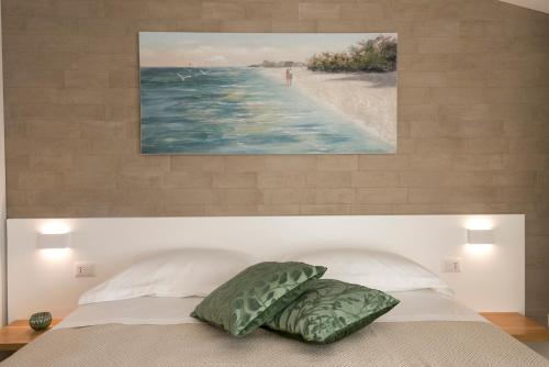 a bedroom with a bed with a painting of a beach at Candiano Palace in Portopalo