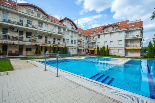a large swimming pool in front of a building at Kis-Gast Panoráma Apartman in Hajdúszoboszló