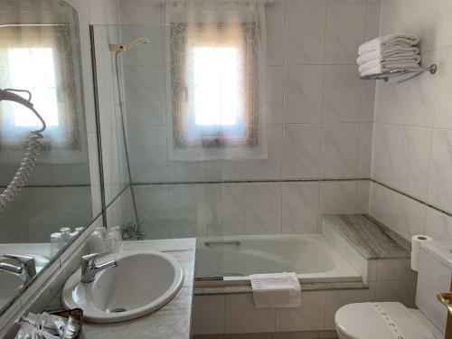 a white bathroom with a tub and a sink at Nueva Colina in Tomiño