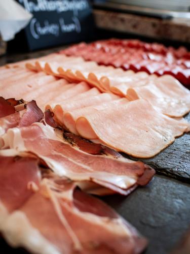 a pile of ham on a table with bacon at Radisson Blu Hotel, St. Gallen in St. Gallen