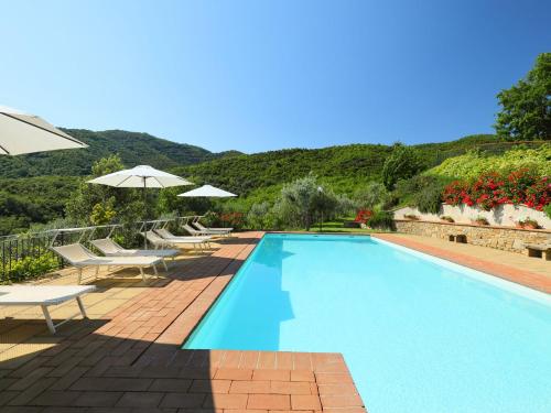 - une piscine avec des chaises et des parasols à côté d'une montagne dans l'établissement Villa Zen by Interhome, à Santa Cristina