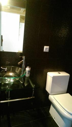 a bathroom with a white toilet and a sink at Casa Rural Ferreiroas Ortigueira in Cuiña