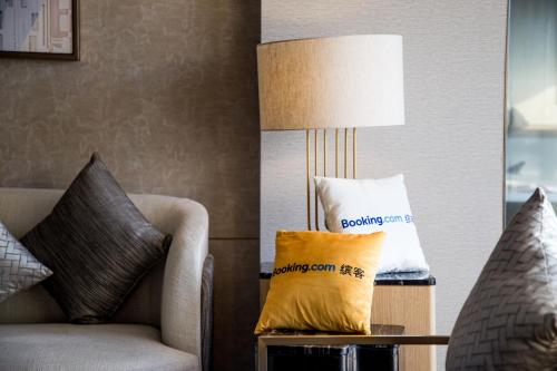 a living room with a couch and a lamp at Millennium Hotel Wuxi in Wuxi