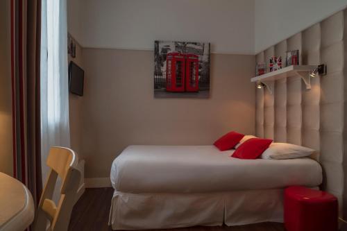 a bedroom with a bed with a red phone booth at The Originals Boutique, Hôtel Le Londres, Saumur in Saumur