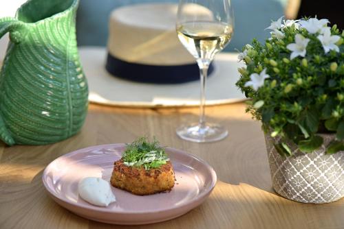 a plate of food on a table with a glass of wine at Chateau La Cheneviere in Port-en-Bessin-Huppain