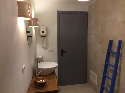 La salle de bains est pourvue d'un lavabo blanc et d'une porte bleue. dans l'établissement Trulli Santa Maria Odegitria Relais, à Ostuni