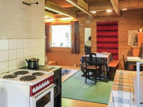 una cocina con fogones y una habitación con mesa en Holiday Home Passimökki by Interhome, en Punkalaidun