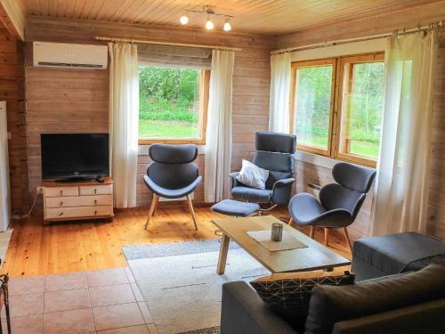 een woonkamer met een bank en stoelen en een tv bij Holiday Home Pihlaja by Interhome in Torvoila