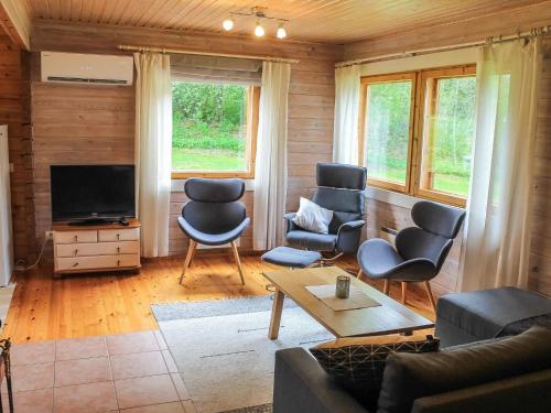 een woonkamer met een bank, stoelen en een tv bij Holiday Home Pihlaja by Interhome in Torvoila