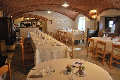 a dining room with tables with white tablecloths at Agriturismo Il Frutto Permesso in Bibiana