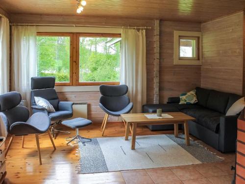 een woonkamer met een bank, stoelen en een tafel bij Holiday Home Pihlaja by Interhome in Torvoila
