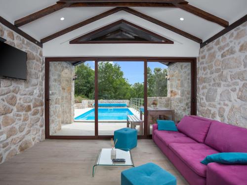 a living room with a purple couch and a pool at Holiday Home Villa Matija by Interhome in Drivenik