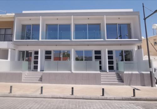 un gran edificio blanco con ventanas de cristal en Shalos Studios en Ayia Napa