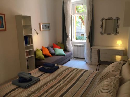 1 dormitorio con cama, sofá y ventana en Rivabahn en Trieste