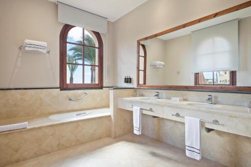
a bathroom with two sinks and a mirror at The Level at Meliá Villaitana in Benidorm
