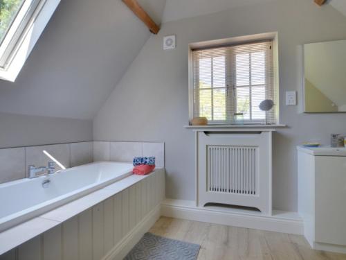 a bathroom with a bath tub and a window at Holiday Home Valley View by Interhome in Weald