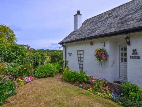 GaerwenにあるHoliday Home Caernarfon View Cottage by Interhomeの庭の花々が咲く白いコテージ