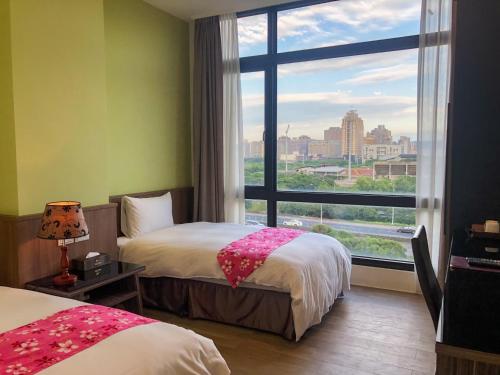 a hotel room with two beds and a large window at Sendale Zhubei Business Hotel in Zhubei