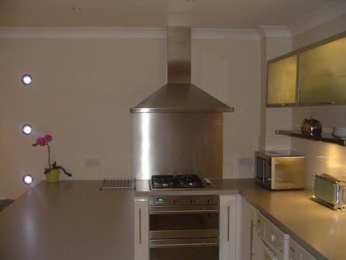 cocina con fogones horno superior junto a un microondas en Aaron Glen Apartments, en Edimburgo