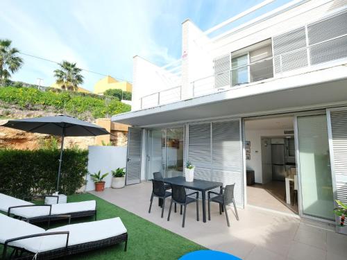 a patio with a table and chairs and an umbrella at Holiday Home Estrella by Interhome in L'Ampolla