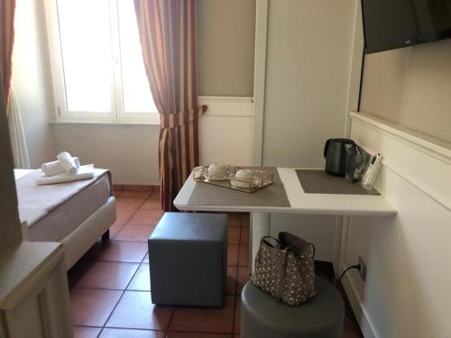 ein kleines Zimmer mit einem Tisch, einem Bett und einem Fenster in der Unterkunft 207 Inn in Rom