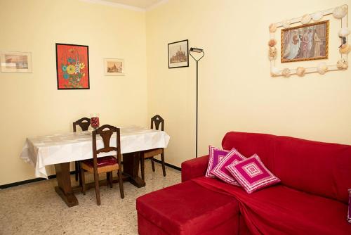 un soggiorno con divano rosso e tavolo di Casa Abba ad Alessandria