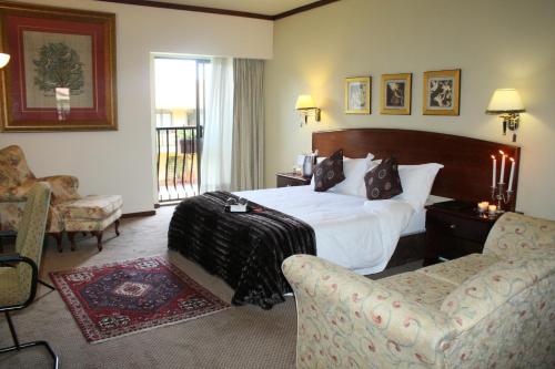 a hotel room with a bed and two chairs at Benvenuto Hotel & Conference Centre in Johannesburg