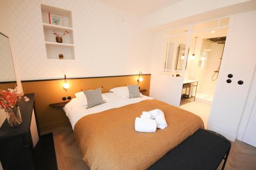 A bed or beds in a room at Maison Paul & Romy- L'horloge