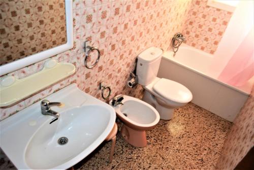 y baño con lavabo y aseo. en Villa Service - Apartamentos Aransol, en El Vendrell