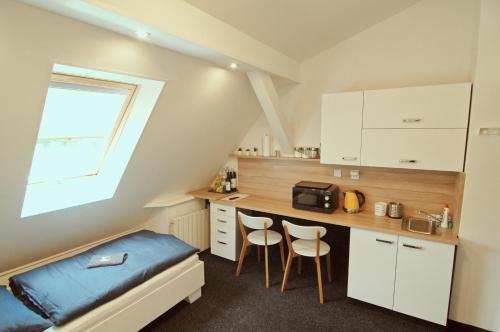 - une cuisine avec un lit et deux chaises dans une chambre dans l'établissement APARTHOTEL VÍTKOVICE, à Ostrava