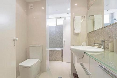 een witte badkamer met een toilet en een wastafel bij Casa Branca by Madeira Sun Travel in Funchal
