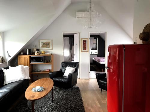 a living room with a black couch and a red refrigerator at Villa Lindell in Höganäs