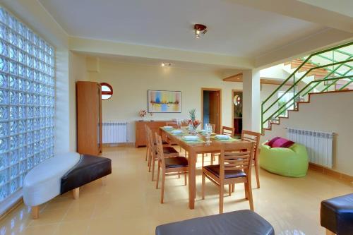a dining room with a table and chairs and a staircase at Vila Marina -BBQ, pool & garden- by Seareen in Albufeira