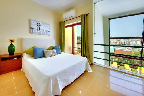 a bedroom with a bed and a large window at Vila Marina -BBQ, pool & garden- by Seareen in Albufeira