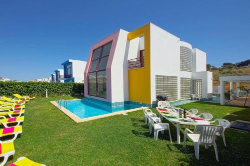 a lawn with tables and chairs and a building at Vila Marina -BBQ, pool & garden- by Seareen in Albufeira