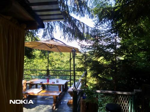a patio with a table and an umbrella at Holiday Home Nature Neno in Visoko
