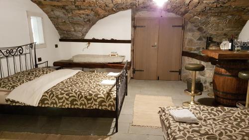 a bedroom with two beds and a stone wall at Wine cellar room in Vipava
