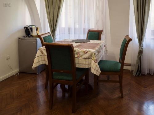 een eettafel met groene stoelen en een tafelkleed bij Gothic Central Sibiu in Sibiu
