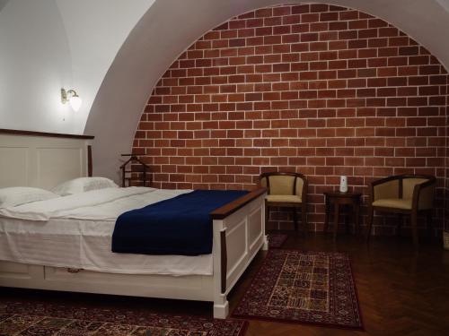 een slaapkamer met een bed en een bakstenen muur bij Gothic Central Sibiu in Sibiu