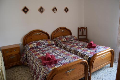 1 dormitorio con 2 camas con sombreros rosados. en Casa Rural Cariño, en Armañanzas